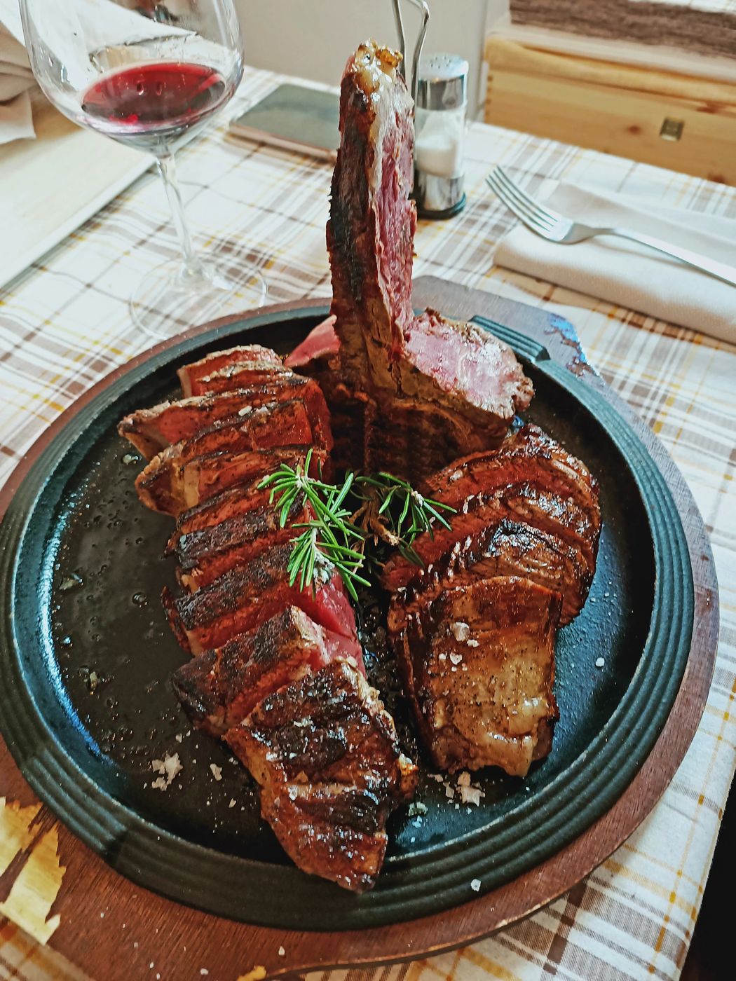 Grilled Fiorentina T-bone served on cast iron — John Bistecchino, steakhouse in Follonica