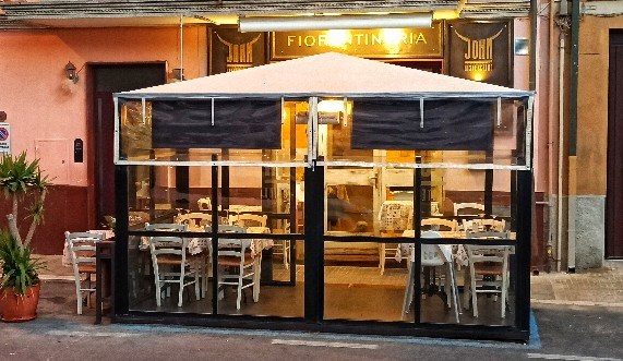 John Bistecchino's outdoor gazebo: 10 street-side seats, warm lights, straw chairs